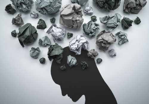 Crumpled up notes, looking like stormy clouds around someone's head, representing what Anxiety can sometimes feel like