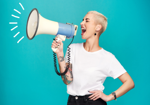 Woman proudly yelling into megaphone, happy with her assertiveness training in Peoria IL