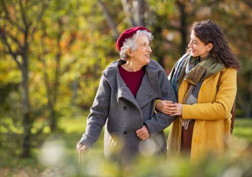 Elderly woman happily walking with daughter