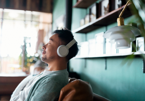 A man listening to music quietly and indulging in self care to improve his mental health
