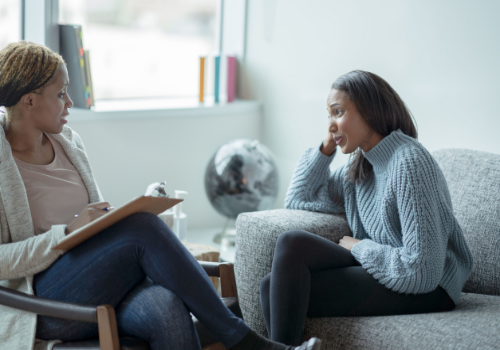 A woman sitting down with a counselor, talking about Anger and Conflict Management in Peoria IL
