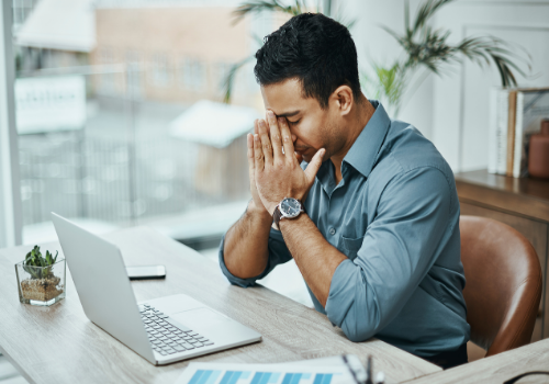 A man on his computer, dealing with Stress Management in Peoria IL