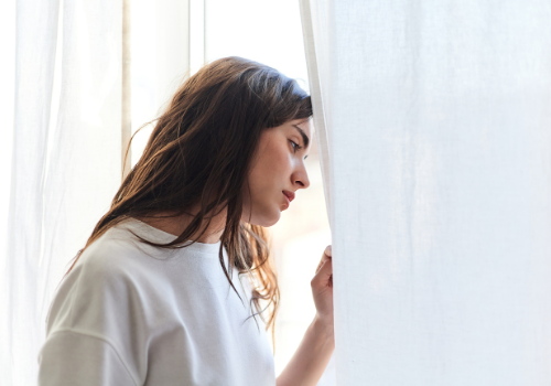 A woman feeling down and depressed and looking out the window, needing Depression Treatment in Peoria IL